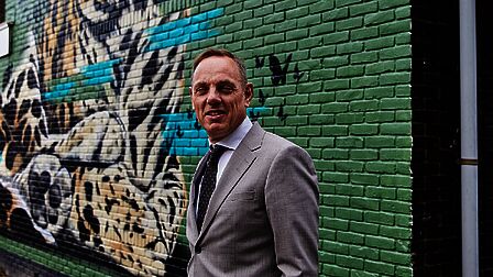 Burgemeester Ron König voor een muurschildering in Sluiswijk
