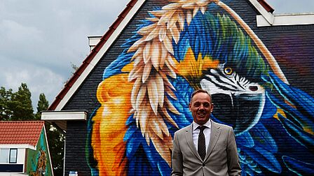 Burgemeester Ron König voor een muurschildering in Sluiswijk